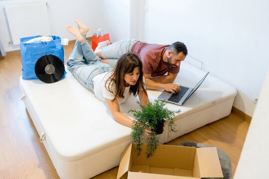 Young couple relax on storage bed during home move