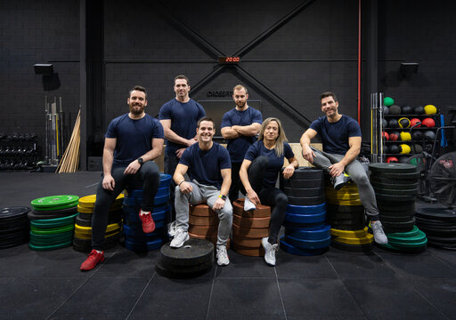 CrossFit team posing with weight plates in gym
