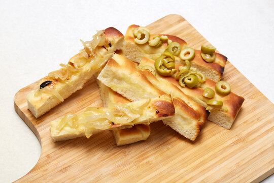 Italian focaccia with onion and olive topping on board