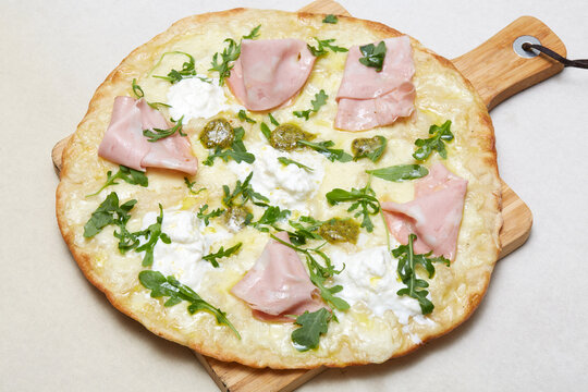 Italian white pizza with ham, cheese and arugula