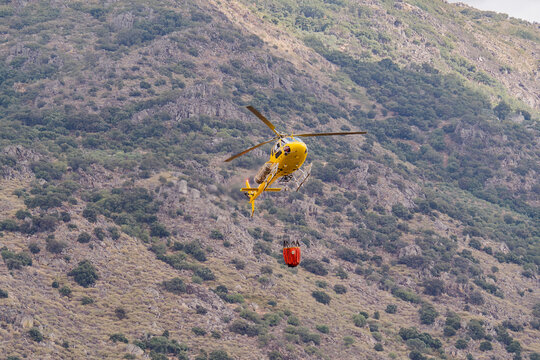 Firefighting helicopter make water drop over wildfire area