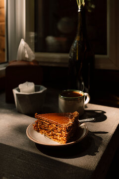Morning coffee and layered cake on A sunlit kitchen table
