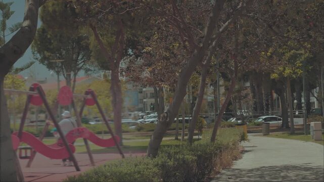 A quiet day in a city square with a playground and a winding walking path. 