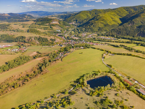 Aerial view of the acid tar lagoons near Predajna surrounded by green fields and the rolling hills of the Low Tatras in Predajna, Banskobystricky kraj, Slovakia.