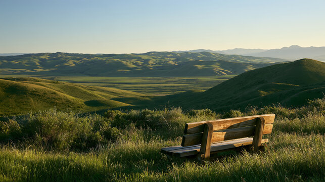 Empty Wooden Bench Overlooking Green Hills and Mountain Landscape