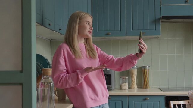 Blonde Woman Enjoying Friendly FaceTime Conversation On Mobile Phone