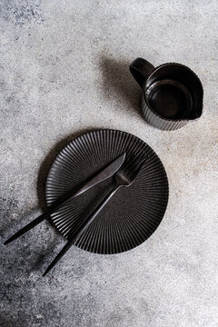 Black dinner tableware set with plate, cup and cutlery