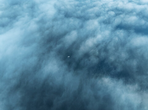 Aerial view of a small boat visible through a dense layer of clouds above Lake Zurich, Zurich, Zurich, Switzerland.