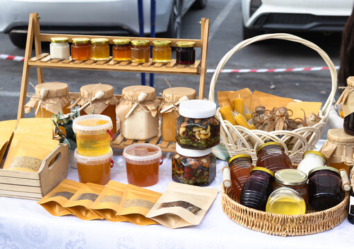Jar of nuts in honey and assorted honey jars at a honey and nut fair