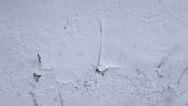 White weathered plaster wall with peeling paint, fine cracks and exposed darker layers. Monochrome surface texture suitable for grunge, aged, architectural and abstract backgrounds.