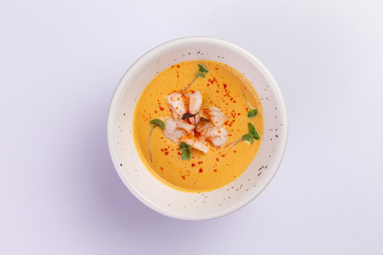 Creamy shrimp bisque in ceramic bowl with paprika garnish fine dining