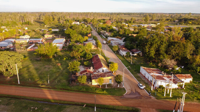 Aerial view of the town of Guaviravi featuring rural houses, dirt roads, and lush green trees in Guaviravi, Corrientes Province, Argentina.