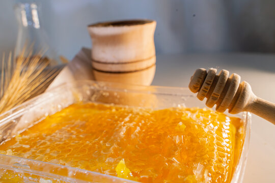 Fresh Honeycomb in Container with Wooden Dipper, Mortar and Wheat
