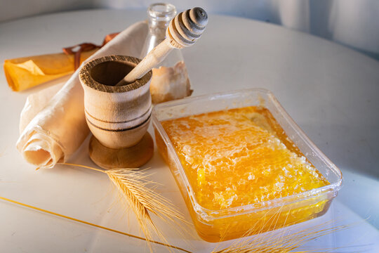 Fresh Honeycomb in Container with Wooden Dipper, Mortar and Wheat