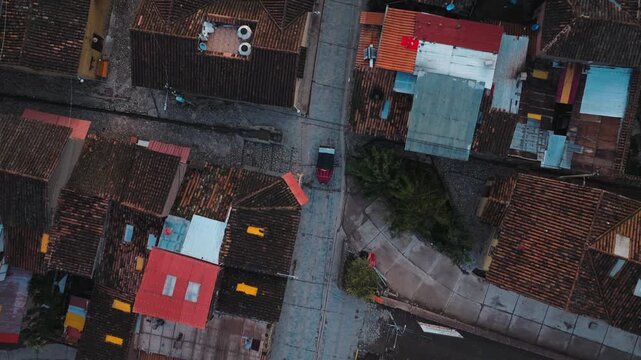 Aerial drone view following a tuk tuk through an Andean town in the Cusco Region of Peru