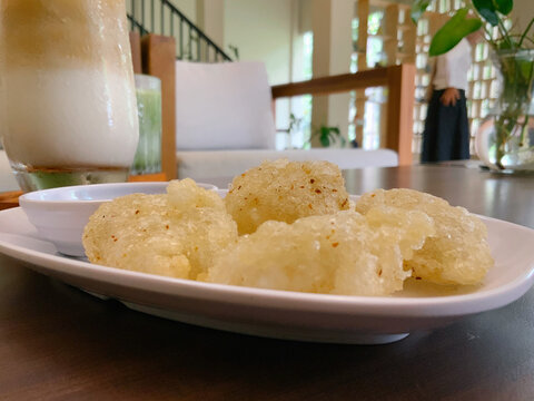 Close-up photo of Cireng, a traditional Indonesian fried tapioca snack, served on a white plate in a cafe