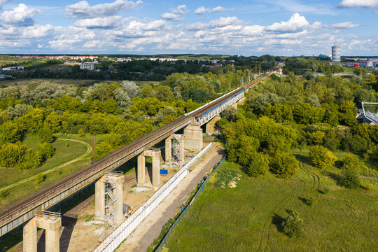 Aerial view of the Elevated Railway Viaduct spanning over lush green vegetation and trees in Poznan, Greater Poland Voivod, Poland.