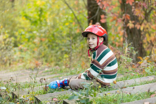 Cute school child, boy, riding roller skates, skating on the street autumn
