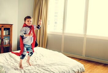 Boy with a superhero custome in a bedroom. © Rawpixel.com
