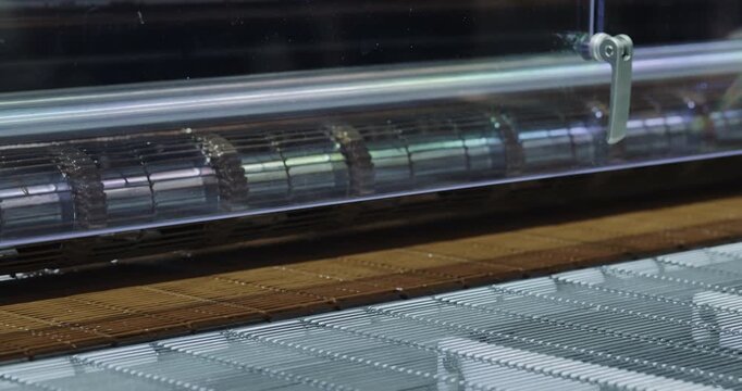 Modern technology of wafer sheet baking and cooling by production line at food factory. Chocolate Ice cream cones material making industrial equipment works in shop