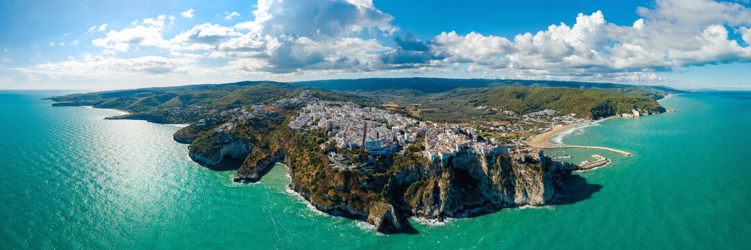 Peschici white town on Gargano peninsula cliffs, aerial wide panorama over Adriatic Sea, Puglia, Italy. 3:1 high resolution coastal landscape, copy space sky and water