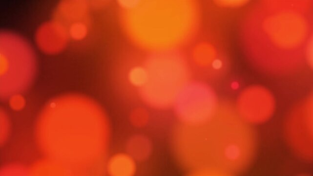 Vibrant red and warm orange abstract bokeh background with floating out-of-focus light circles. Festive glowing bokeh lights backdrop for Christmas and Valentine events.