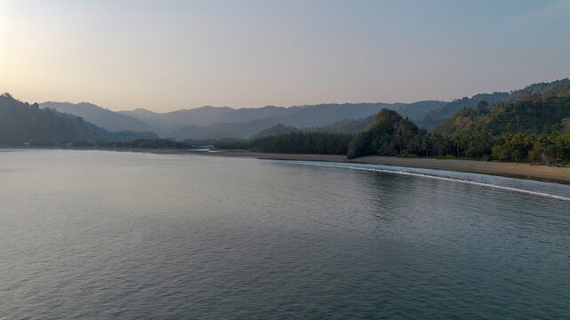 Aerial panoramic view of Pujiharjo beach bay surrounded by green hills in Malang East Java