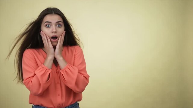 People - Shocked caucasian woman with wide eyes and open mouth touching her face in surprise against a yellow background