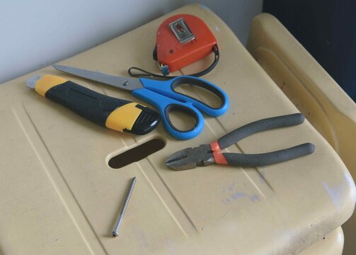 Tools are placed on a yellow work surface showing a project in progress