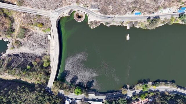 Top down aerial stock footage of San Roque dam wall and spillway funnel in Cordoba