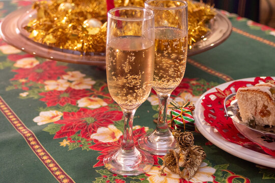Celebrating Christmas and New Year with festive toasts, sparkling champagne flutes and decorative ornaments on a traditional seasonal table setting