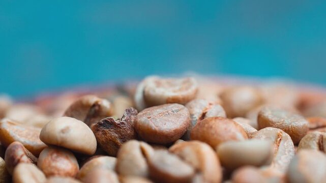 Macro close up shot of unroasted raw green coffee beans heap with selective focus.
