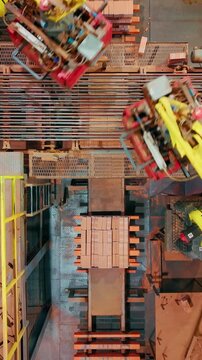 Industrial robots palletizing bricks at a brick factory top down aerial view