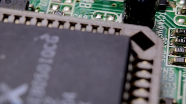 View of a part of an electronic printed circuit board with SMD components and a large microcircuit, video macro shooting