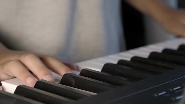 Talented child's hands playing electronic piano keyboard
