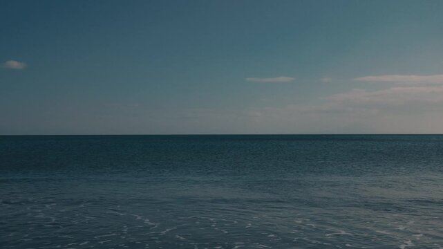 Wide Gradient Blue Sky Over a Quiet Beach Shoreline from a Low Angle
