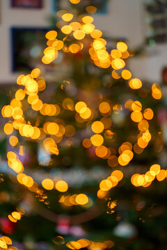 Warm defocused Christmas tree lights creating a golden bokeh background with cozy festive holiday atmosphere.