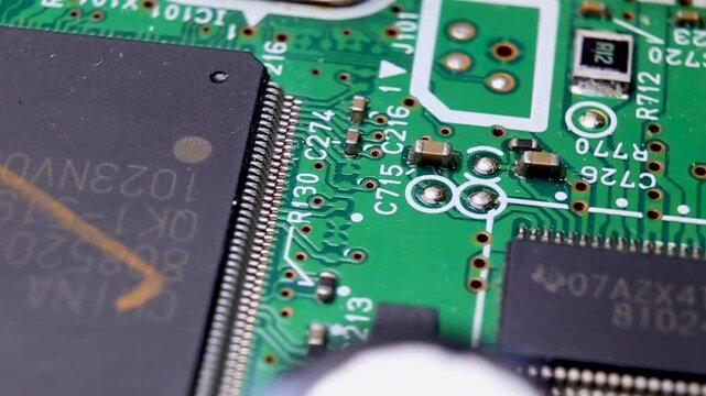 View of a part of an electronic printed circuit board with SMD components and a microcircuit, video macro shooting