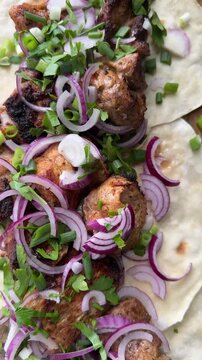 succulent pieces of charcoal-grilled shashlik sprinkled with herbs and onions, served on lavash bread. High quality 4k footage