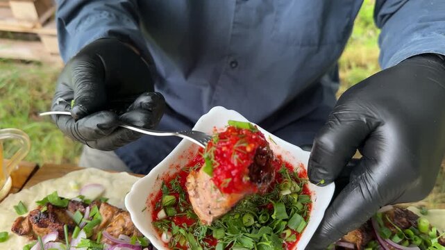 A piece of juicy shashlik on a fork being dipped into sauce, pieces of meat served on lavash bread with a glass of cold beer. High quality 4k footage