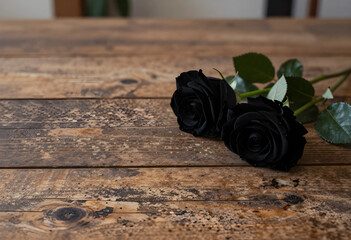 Fototapeta premium Mourning and loss concept, two black roses on a rustic wooden table for funeral sympathy, grief and remembrance with dark floral aesthetic for memorial