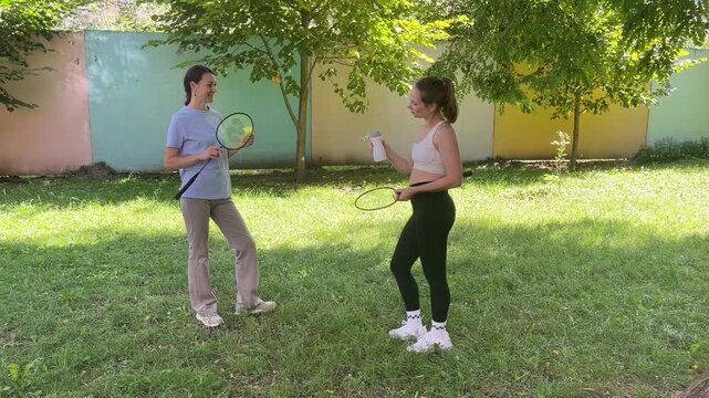 Two young women rest after tennis sport practice outdoors