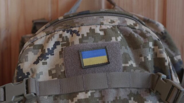Tactical military backpack with Ukrainian flag patch hanging in bunker