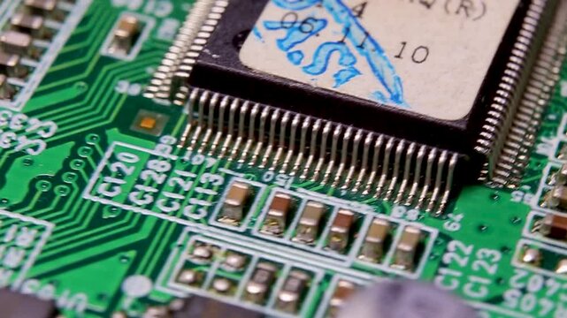 Part of an electronic printed circuit board with electronic components and connections, video macro shooting