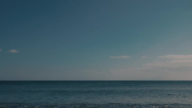 Wide Gradient Blue Sky Over a Quiet Beach Shoreline from a Low Angle
