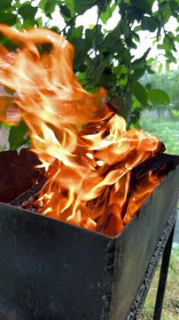 Close-up of flames scattering in the wind from a barbecue grill outdoors. High quality 4k footage