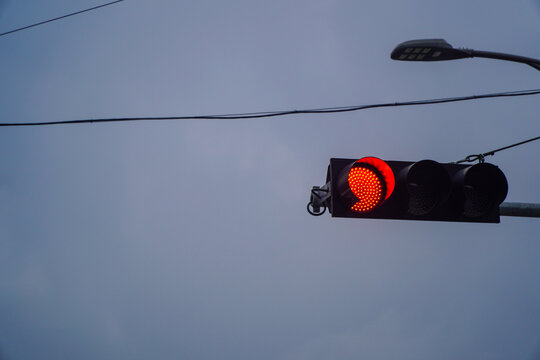 Illuminated Red Traffic Light with Led Display Indicating Stop Against a Calm Sky