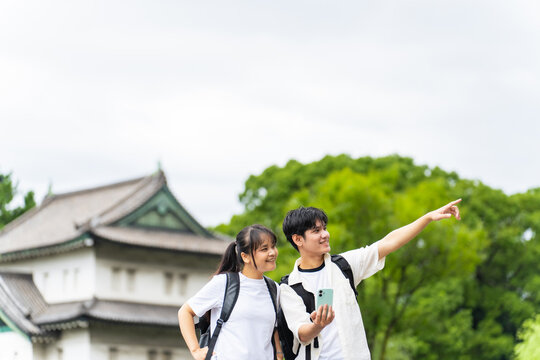 日本の観光地を旅行するアジア人観光客のカップル。インバウンド、観光、名所、スマホ、アプリ、口コミ