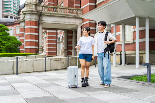 旅行するアジア人観光客のカップル。旅行者、観光、インバウンド、笑顔、外国人、ホテル、宿泊、駅、民泊