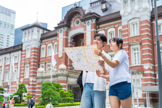 地図を見るアジア人観光客のカップル。旅行、観光、ガイドマップ、インバウンド、笑顔、外国人、観光地